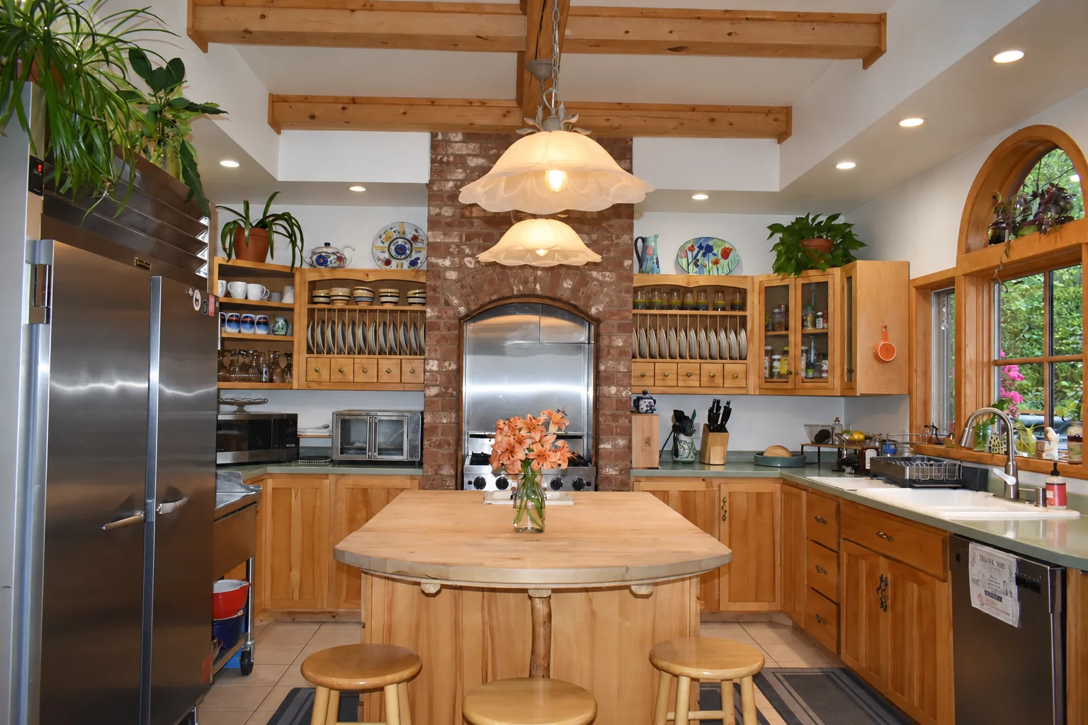 Shared guest kitchen with a full-size refrigerator beside the wooden island at Denali Overlook Inn