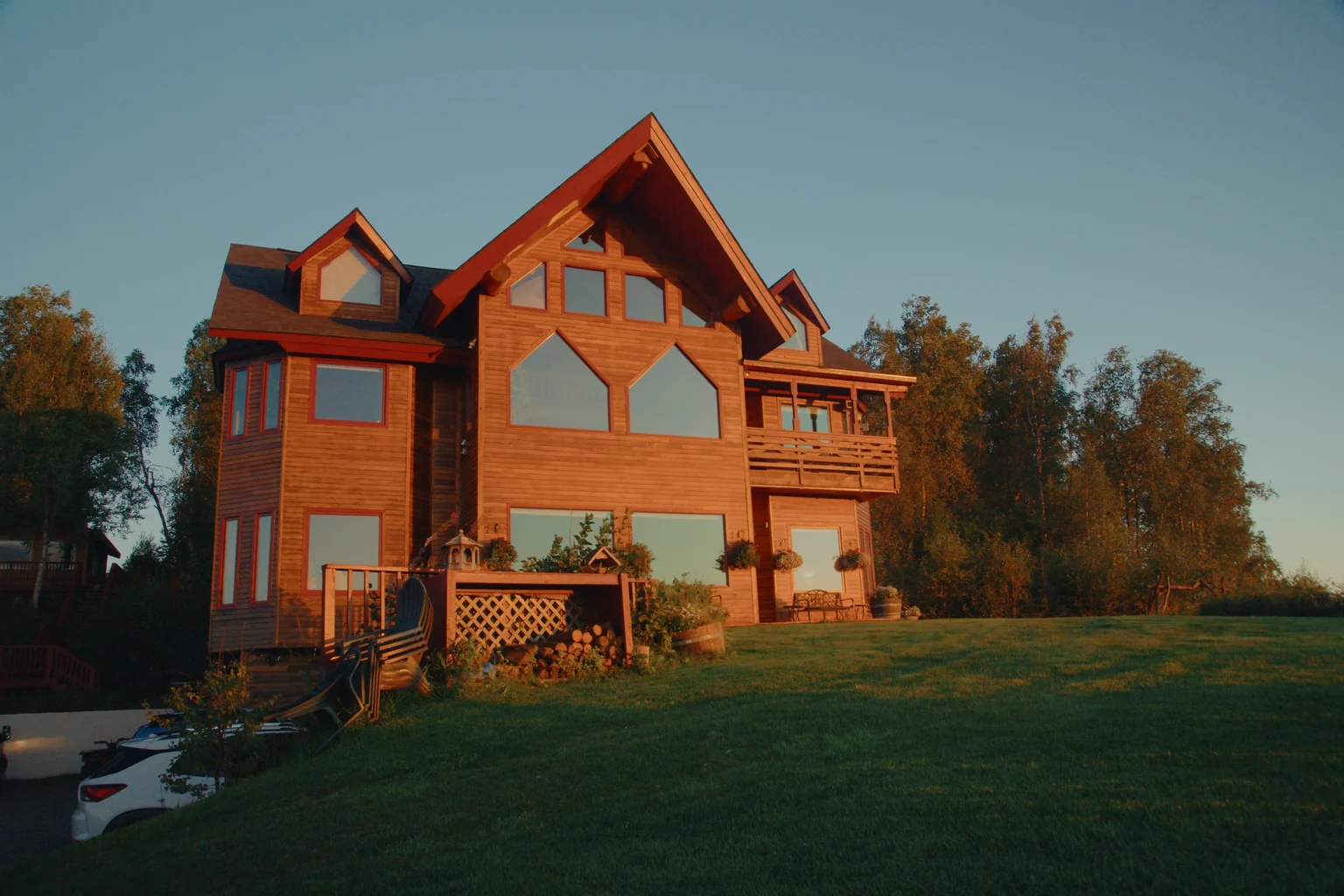 Denali Overlook Inn timber-frame lodge illuminated by warm evening light in Talkeetna, Alaska