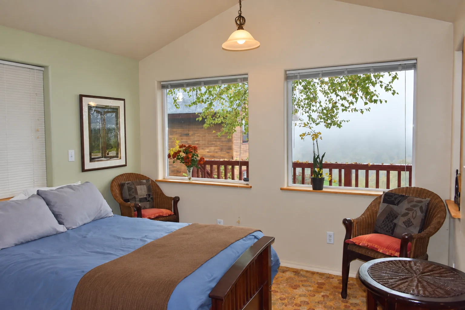 Bedroom with a queen bed and surrounding windows in Northern Exposure Cabin