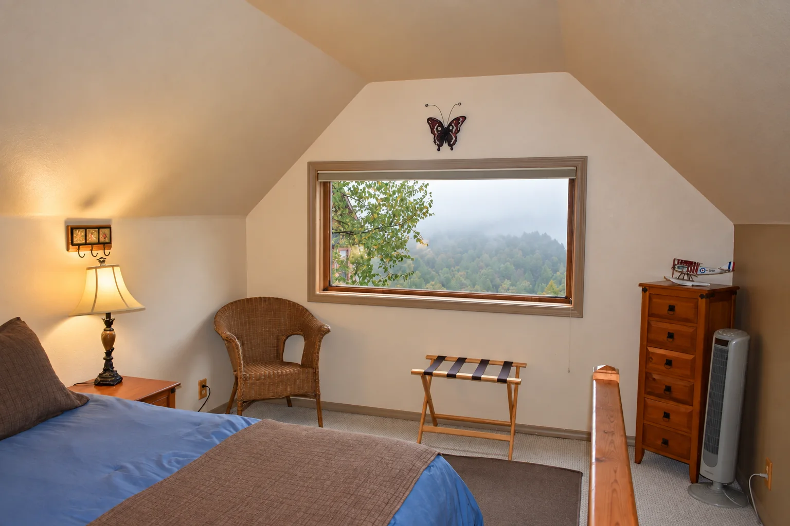 Upstairs bedroom with queen bed and forest view in Northern Exposure Cabin