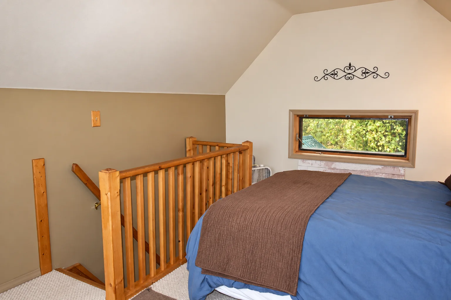 Upstairs sleeping area beside the wooden staircase in Northern Exposure Cabin
