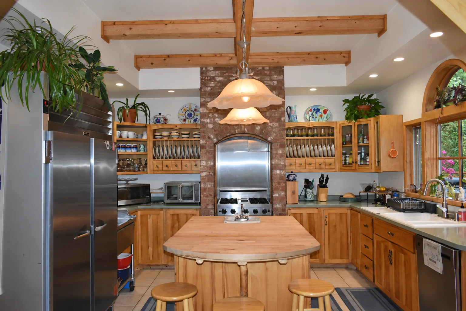 Shared guest kitchen with wooden island at Denali Overlook Inn