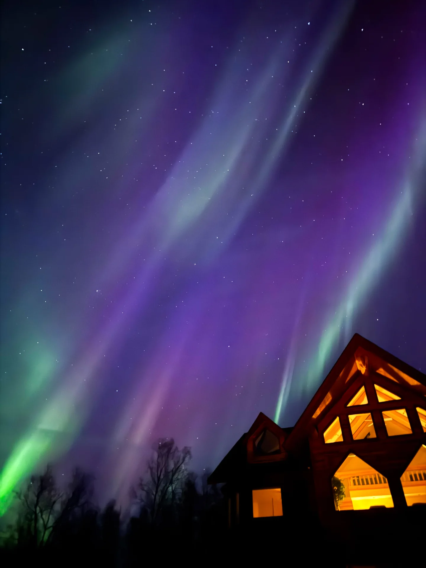 Northern lights stretching above the roof of Denali Overlook Inn